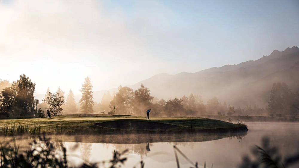 Golfplatz bei Zell am See mit Wasser und Bergen im Hintergrund